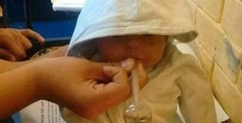 رضيع يدخن المخدرات بيد والدته